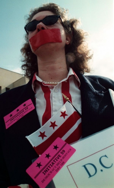 Karen Szulgit protests her lack of voting rights at rally before arguments in court.