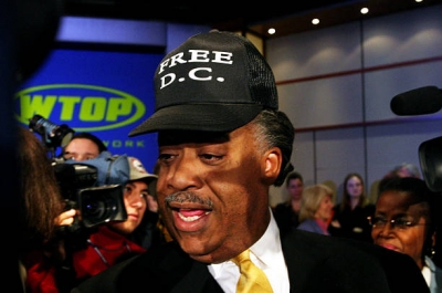 Democratic Presidential candidate Rev. Al Sharpton sports a ‘Free DC’ hat after a debate with fellow candidates Carol Mosley Braun and Rep. Dennis Kucinich at George Washington University during a forum sponsored by WTOP radio. January 9, 2004