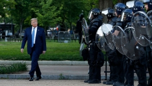 President Donald J. Trump walks past police in Lafayette Park after visiting outside St. John&#039;s Church across from the White House in Washington, DC, on Monday, June 1, 2020. Part of the church was set on fire during protests on Sunday night.