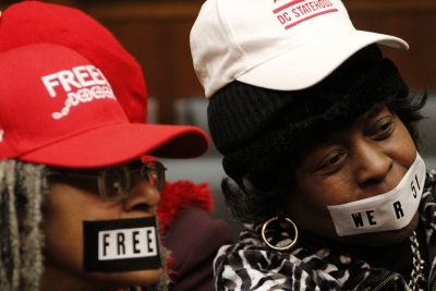 D.C. residents at the markup on Monday wearing hats and tape to protest Congress’ control over local legislation.